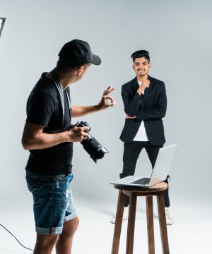 Professional photographer taking photos of indian model in studio with leight